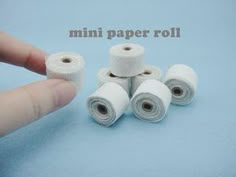 four rolls of toilet paper sitting next to each other on a blue background with the words mini paper roll