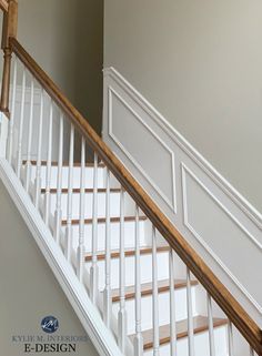 an empty staircase with white railings and wood handrail