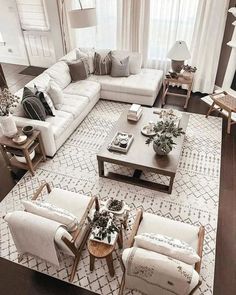 a living room filled with white furniture and lots of pillows on top of it's couches