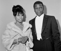 a black and white photo of a man and woman in formal wear standing next to each other