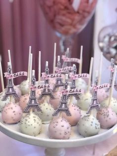 cake pops with pink and white frosting in front of the eiffel tower