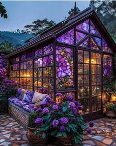 a glass house with lots of windows and purple flowers