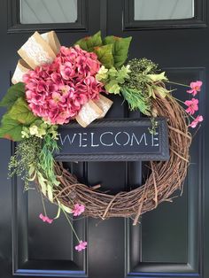 a welcome wreath with pink flowers and green leaves