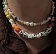 a woman wearing a multicolored necklace with words on it