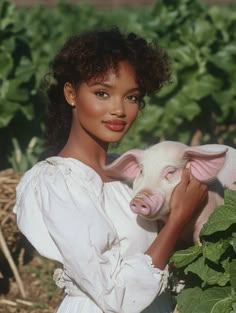 a woman in a white dress holding a pig