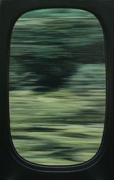 an airplane's window is shown with blurry trees in the background