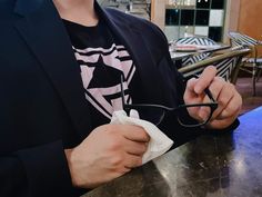 a man sitting at a table with glasses in his hand and napkins in front of him