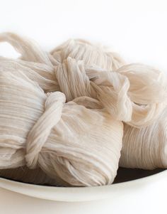 a white bowl filled with yarn on top of a table