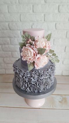 a three tiered cake with flowers on top