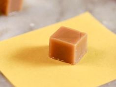 two square pieces of chocolate sitting on top of a yellow napkin next to each other