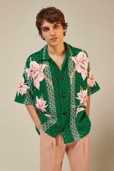 a man wearing a green shirt with pink flowers on it