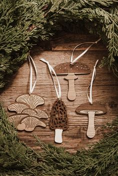 an assortment of wooden mushrooms are arranged in a circle on a wood surface surrounded by greenery