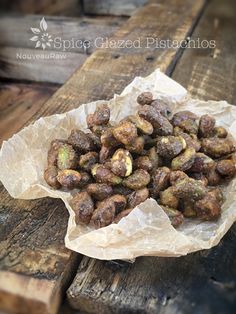 a bowl full of nuts sitting on top of a wooden table next to a piece of paper