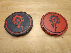 two red and black frisbees sitting on top of a wooden table