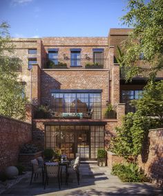 an outdoor dining area in front of a brick building with lots of windows and balconies