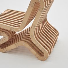 two wooden chairs sitting next to each other on top of a white surface with holes in the back