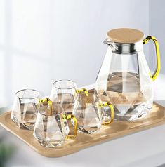 a pitcher and six glasses on a tray