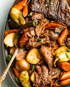 a pot roast with potatoes and carrots on a platter, ready to be eaten