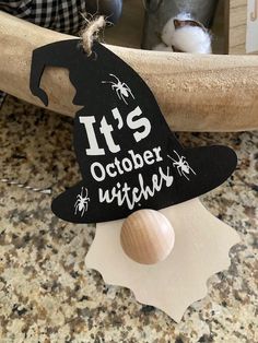 it's october witches hat on top of a piece of wood next to a bird