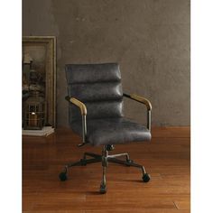 an office chair sitting on top of a hard wood floor next to a framed photo