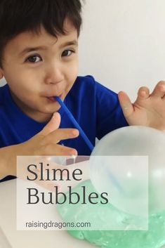 a young boy sitting at a table with a bubble wand in his mouth and the words slime bubbles above him