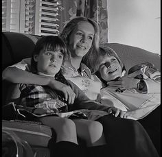 a woman and two children sitting on a couch