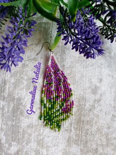 purple flowers and green leaves are hanging from a branch with the words congratulations written on it