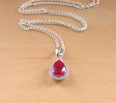 Sterling+silver+pendant+set+with+ruby+corundum+gemstone+with+crystal+zirconia+studded+surround.+This+beautiful+ruby+gemstone+is+created+in+laboratory+conditions+from+the+chemical+components+of+the+mineral+corundum+that+occur+in+the+natural+gemstone+ruby.+The+pendant+measures+1.4cm+length+x+1cm+wi... Ruby Jewellery, Pear Pendant, Ruby Necklace, Classy Jewelry, Cz Pendant, Ruby Jewelry, July Birthstone, Ruby Gemstone, Red Ruby