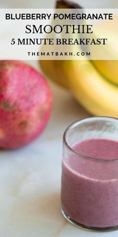 blueberry pomegranate smoothie in a glass next to bananas