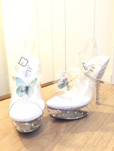 two white shoes with butterfly decorations on them