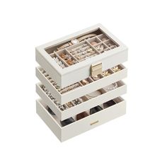 three white drawers with jewelry in them