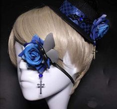 a white mannequin head with blue roses and cross on it's side