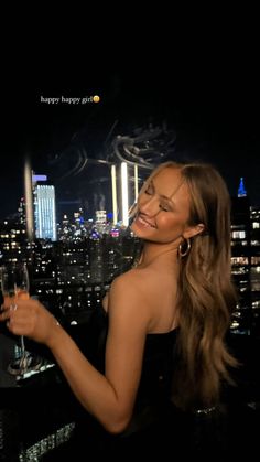 a woman holding a wine glass in front of a cityscape with skyscrapers