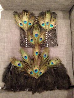 several peacock feathers are placed on the back of a chair with silver sequins