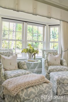 a living room with two couches and a coffee table in front of a window