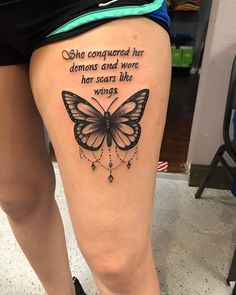 a woman's thigh with a butterfly tattoo on it and the words she congregated her demons and were her scars like wings