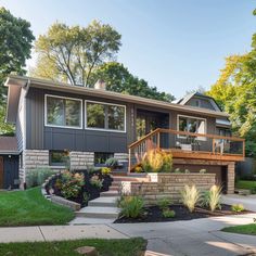 a house with landscaping in the front yard and steps leading up to it's second story