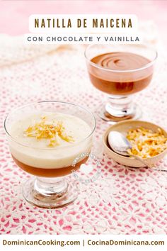 two glasses filled with chocolate pudding on top of a pink table cloth next to spoons