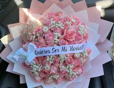 a bouquet of pink roses and baby's breath with a message on the ribbon