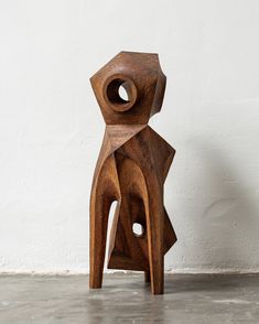 a wooden sculpture sitting on top of a cement floor