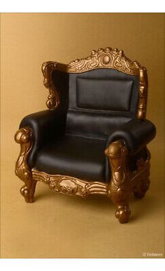 a gold and black leather chair on a brown background