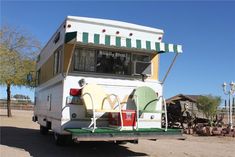 an rv parked in the middle of a dirt lot