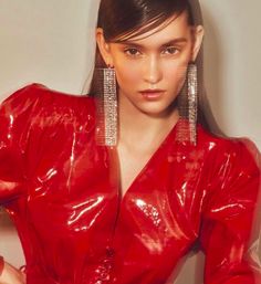 a woman in a red dress is posing for the camera