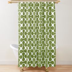 a green and white shower curtain with circles on the bottom, in front of a bathtub