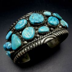 "VINTAGE NAVAJO BRACELET DESCRIPTION: This impressive cuff features 21 specimens of blue Arizona turquoise.. The gemstones are secure in smooth bezel, on a foundation of heavy gauge vintage sterling silver. Plump applied raindrops punctuate the turquoise cabochons and chisel stamped designs frame the edges. This fine bracelet will be a cherished addition to your collection of fine vintage Native American jewelry. MEASUREMENTS: Interior of the cuff measures 5 7/8\" with an additional 1 1/4\" non- Blue Collectible Cuff Bracelet Bangle, Vintage Turquoise Bangle Cuff Bracelet, Handmade Turquoise Vintage Cuff Bracelet, Vintage Blue Cuff Jewelry, Vintage Blue Cuff Bracelet, Vintage Blue Bangle Bracelets, Vintage Turquoise Cuff Bracelet, Bones Bracelet, Vintage Native American Jewelry