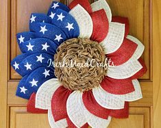 a patriotic wreath on the front door with red, white and blue burluck