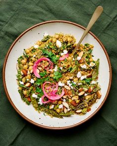 a white bowl filled with food on top of a green table cloth