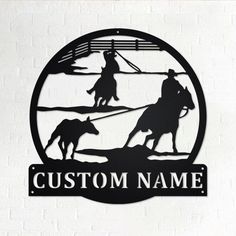 a metal sign that says custom name with two cowboys on horses and a lasso