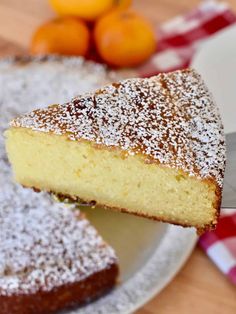 a piece of cake sitting on top of a white plate next to oranges and a knife