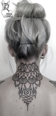 the back of a woman's neck with an intricate tattoo design on her neck